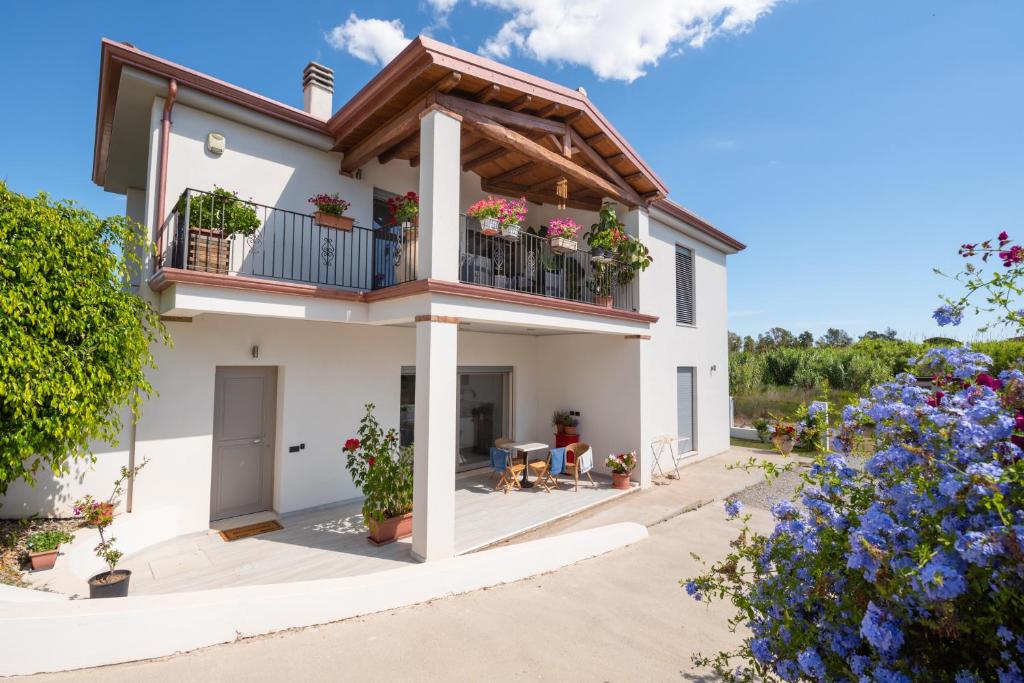 uma casa com uma varanda com flores em Giglio Marino em Tortolì