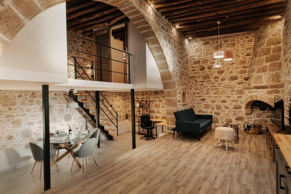 an old brick walled room with a table and chairs at La casa dell'arch in Haraki