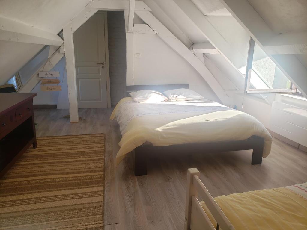 a bedroom with two beds in a attic at Les 2 chaumières avec piscine in Épinay