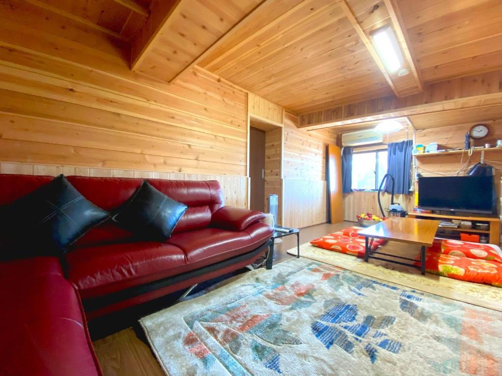 uma sala de estar com um sofá vermelho e uma mesa em Fukouji - Vacation STAY 07341v em Numata