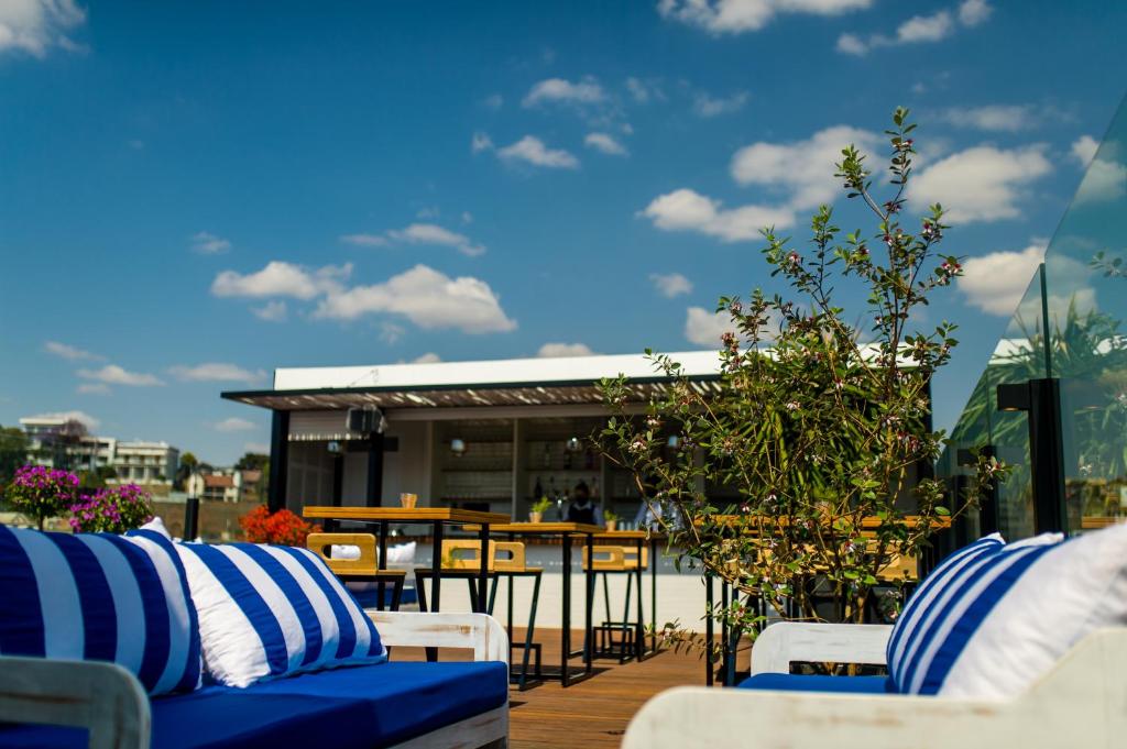 塔那那利佛的住宿－格蘭德都市酒店，庭院配有蓝色和白色的椅子和桌子