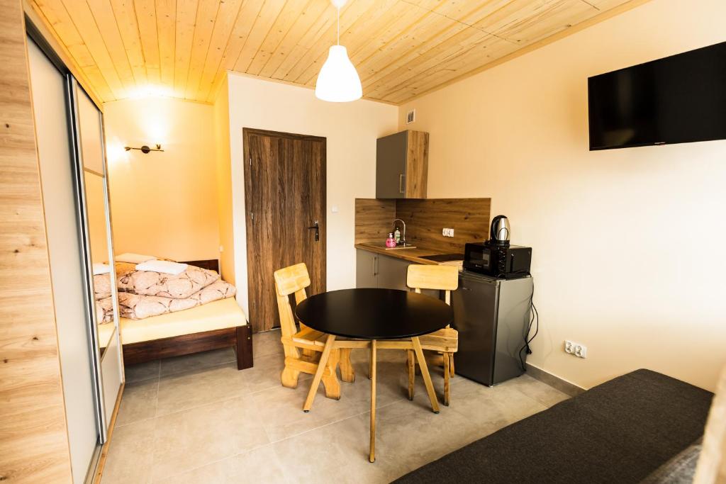 a small room with a table and a bedroom at L&B Szczyrk Centrum in Szczyrk