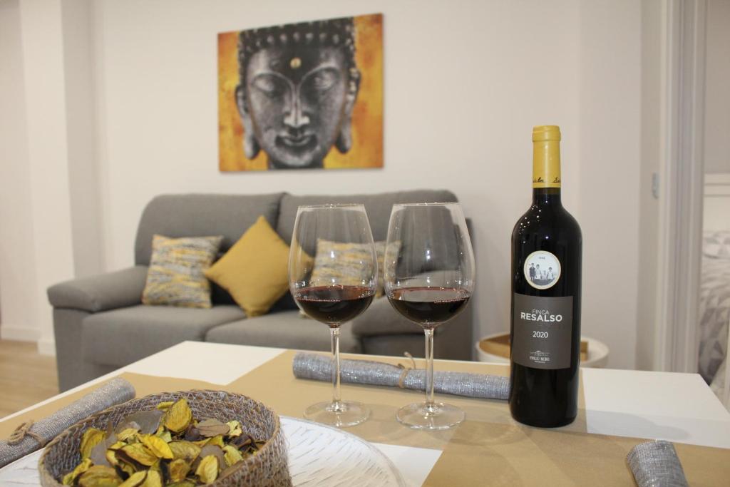 a bottle of wine and two wine glasses on a table at Apartamento Catedral in Almería