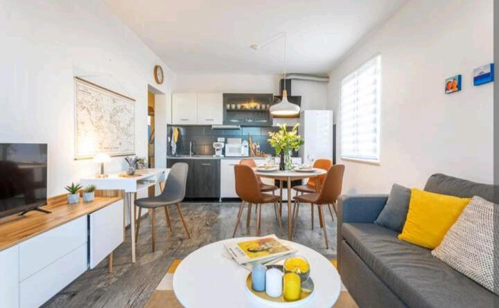 蘇佩塔爾的住宿－Apartman Olive，客厅以及带沙发和桌子的厨房。