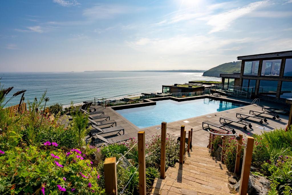 a house with a swimming pool next to the ocean at Carbis Bay and Spa Hotel in St Ives