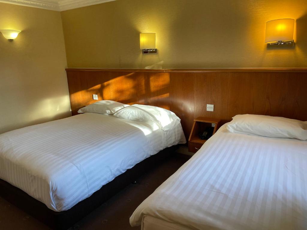 Postel nebo postele na pokoji v ubytování Orchard Hotel
