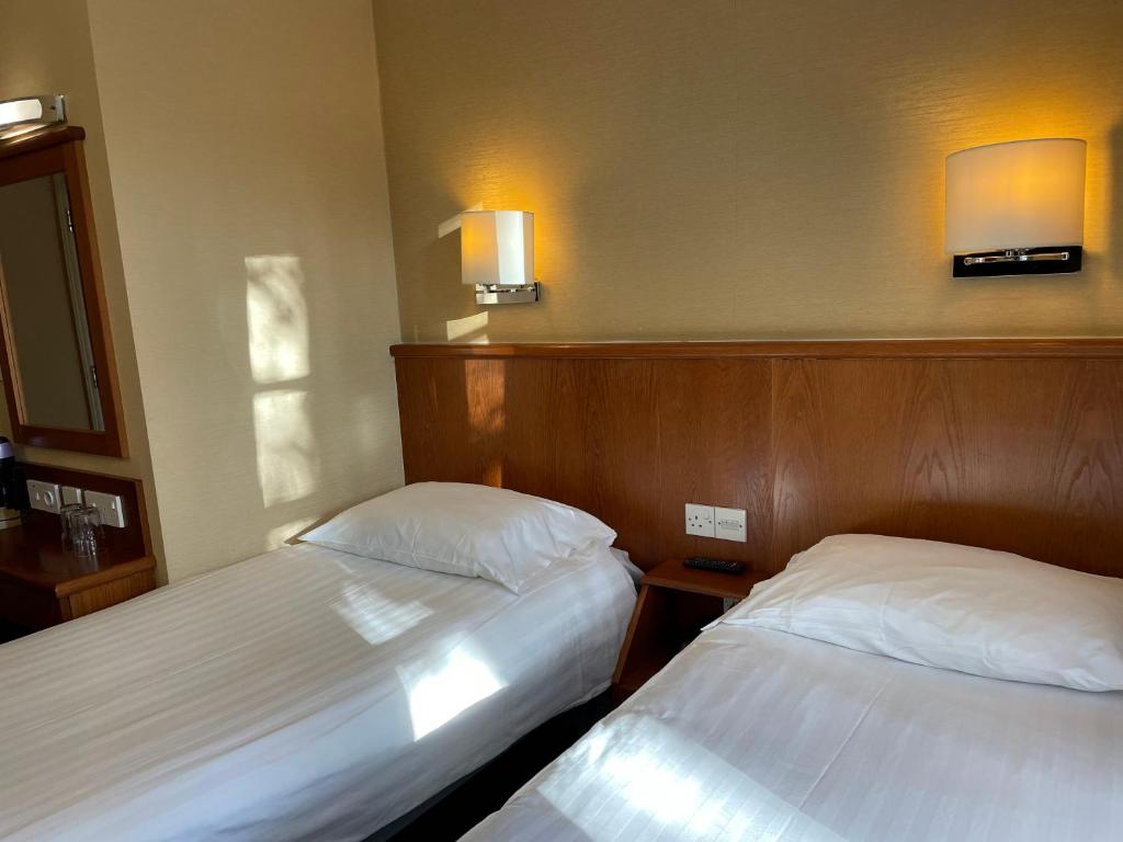 Postel nebo postele na pokoji v ubytování Orchard Hotel