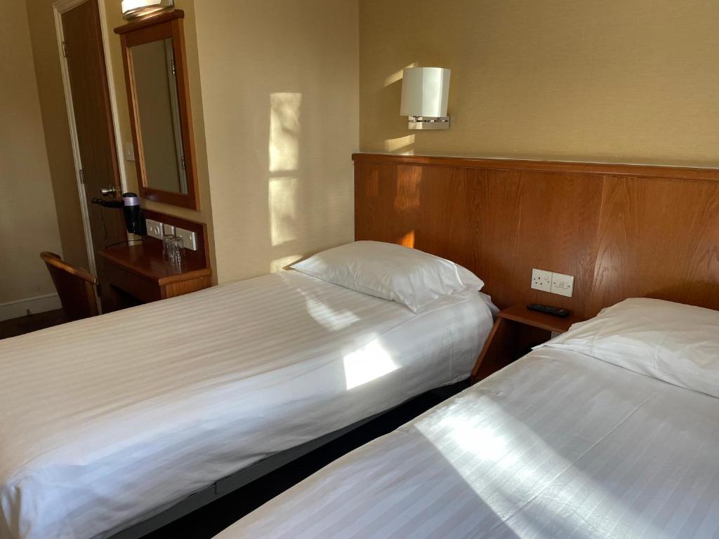 Postel nebo postele na pokoji v ubytování Orchard Hotel