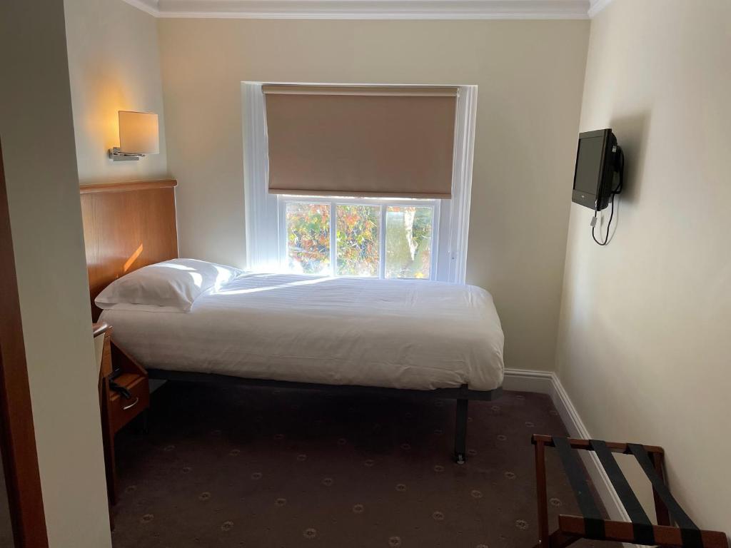 Postel nebo postele na pokoji v ubytování Orchard Hotel