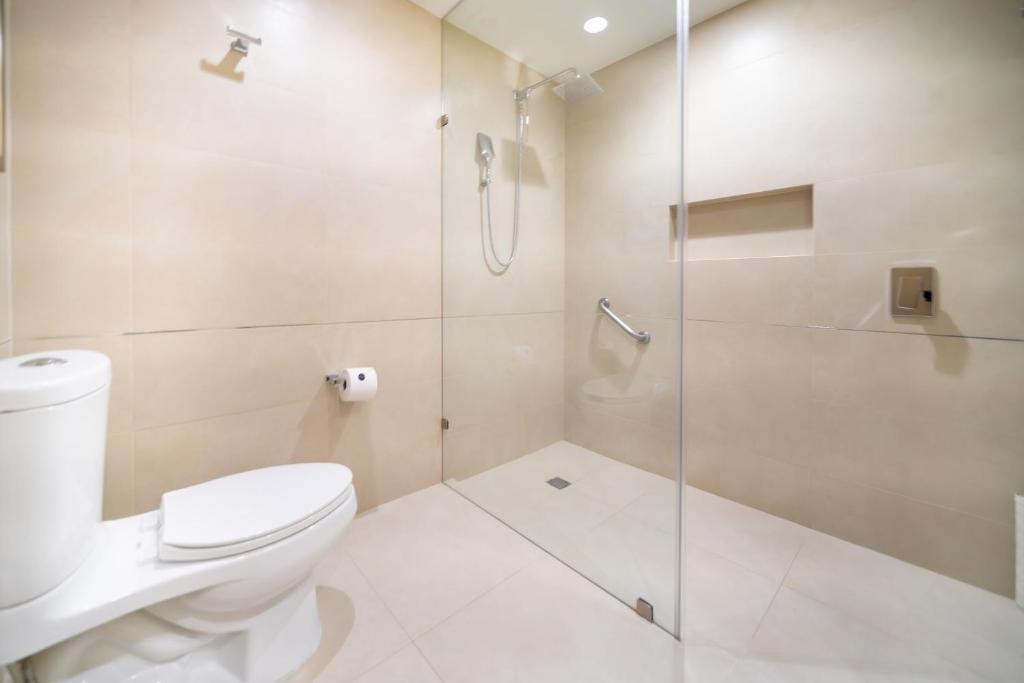a bathroom with a toilet and a glass shower at Metria Hotel in León