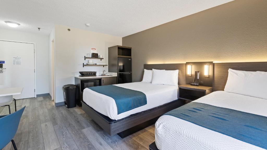 a hotel room with two beds and a desk at Studio 6 Tucson, AZ - North in Tucson