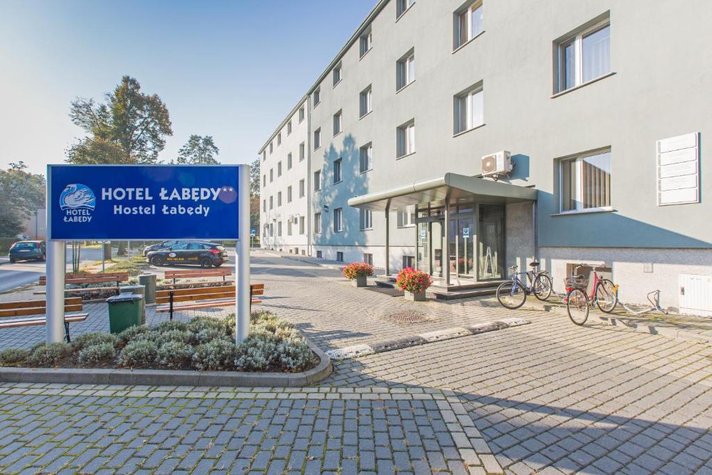 ein Schild vor einem Gebäude auf einer Straße in der Unterkunft Hotel Łabędy in Gliwice