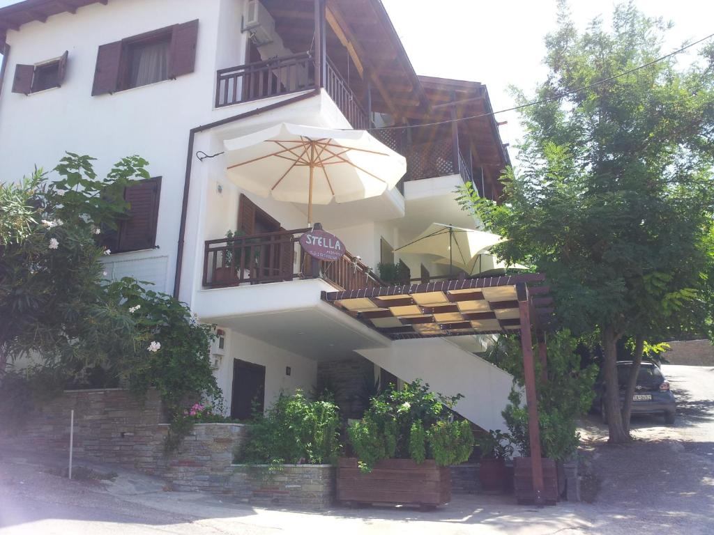um edifício branco com uma varanda e um guarda-chuva em Stella Maisonettes em Ammouliani