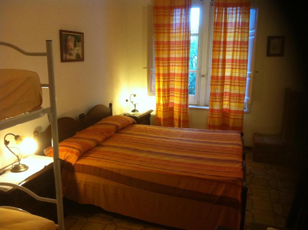 1 dormitorio con 1 cama y una ventana con cortinas en Agriturismo La Calabrisella en Davoli