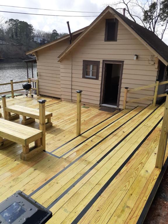 a wooden deck with a picnic table and a house at Edgewater Resort Cottage #1 in Hot Springs