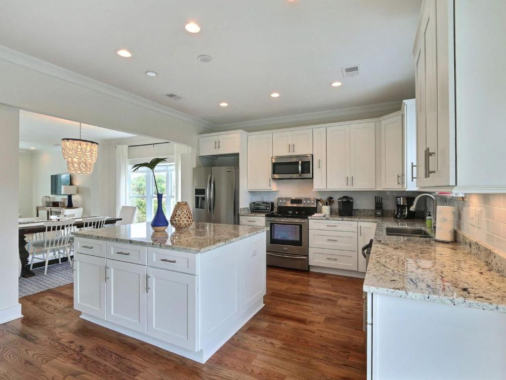 a kitchen with white cabinets and marble counter tops at General George Marshall in Tybee Island