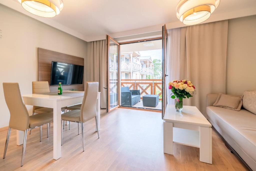 un soggiorno con tavolo e divano di Apartament Flores 3 Rezydencja Park Rodzinna - Mielno a Mielno