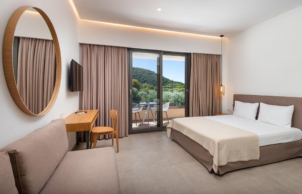 a bedroom with a bed and a desk and a mirror at Urania Hotel in Perdika