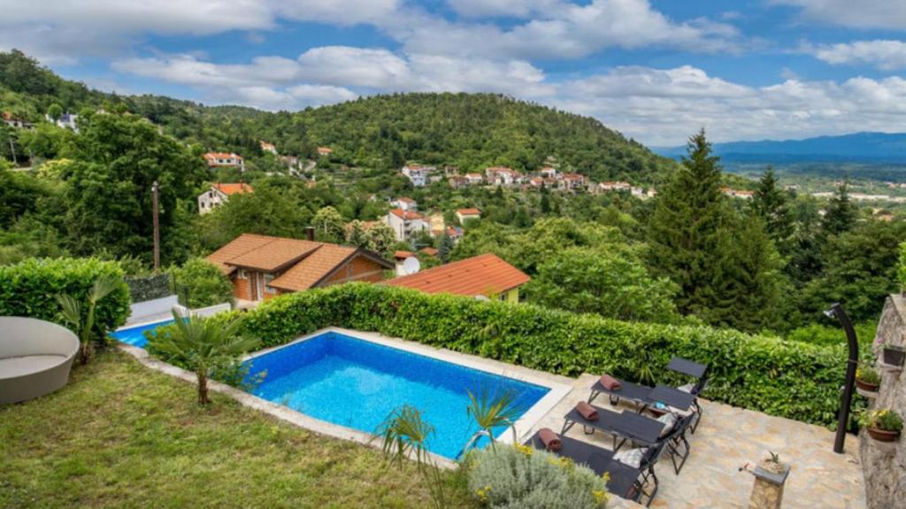 a swimming pool in a garden with a view of a city at TOTO I LALA in Rukavac