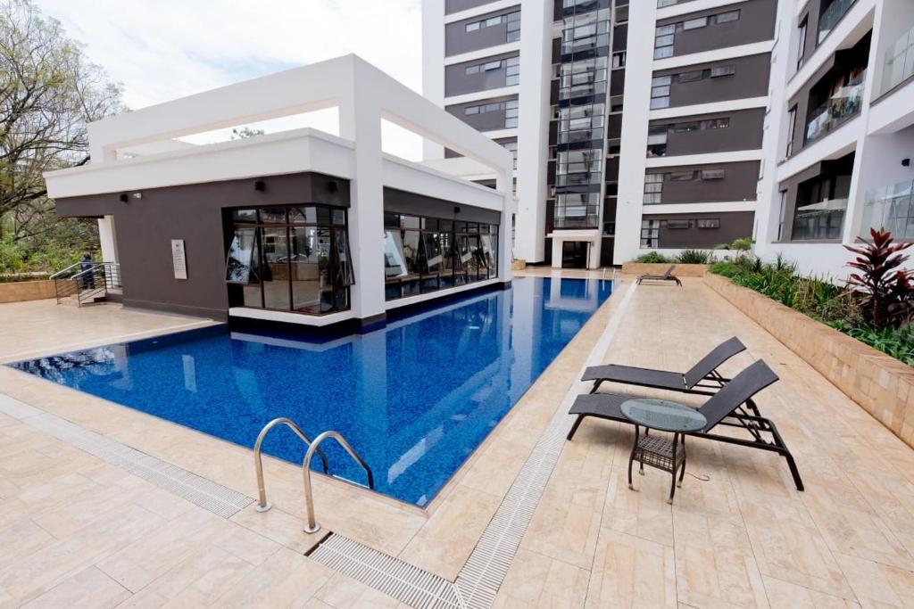 a swimming pool in front of a building at Astoria apartments in Nairobi