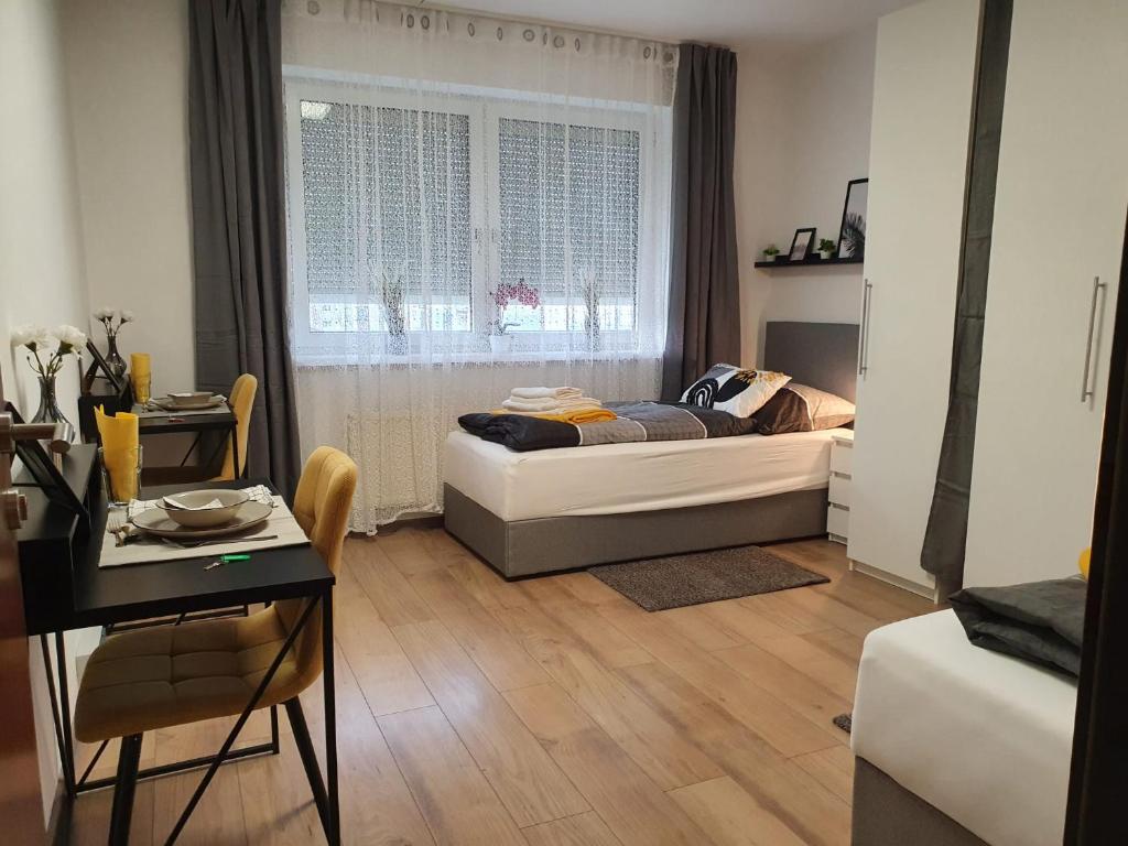 1 dormitorio con cama, mesa y ventana en Leon2, en Linz