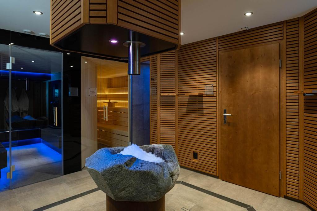 a room with a rock in the middle of a building at Hotel Caprice - Grindelwald in Grindelwald