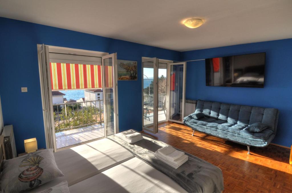 a living room with blue walls and a couch at Apartments Kety - Central heating in Crikvenica