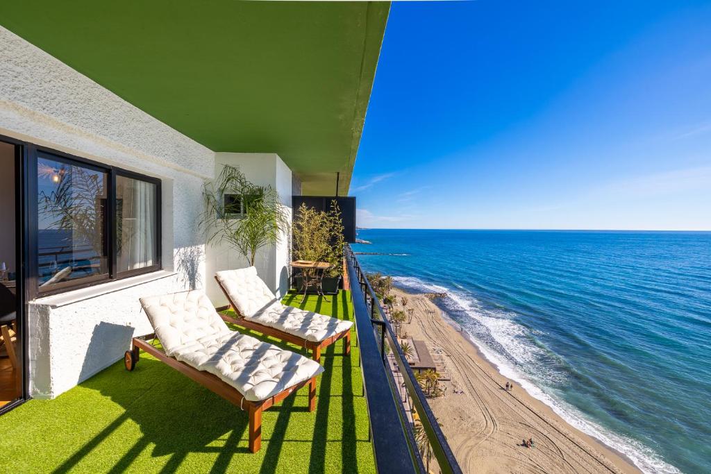 a balcony with two chairs and a view of the ocean at Marbella Venus beach and Sea view apartment in Marbella