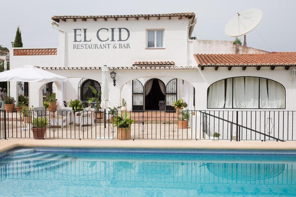 un bâtiment avec une piscine en face d'un bâtiment dans l'établissement El Cid Country Club, à Benidoleig