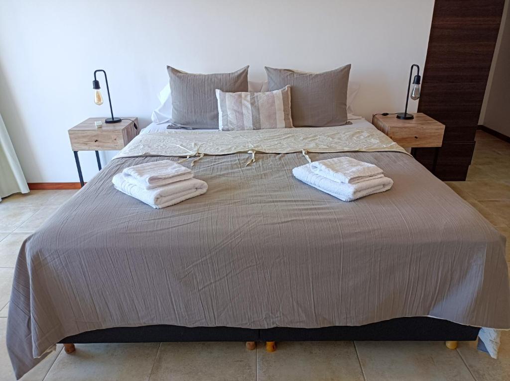 Una cama con dos toallas encima. en Solar de Roca en Embalse