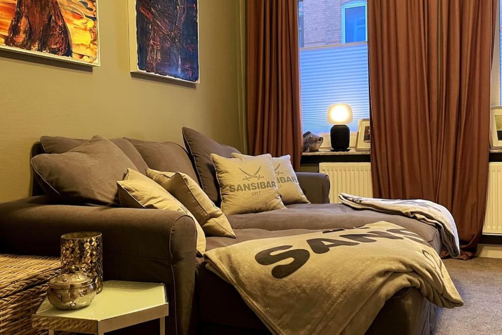 uma sala de estar com um sofá e uma janela em Altbaucharme Deluxe mit Terrasse in zentraler Lage em Kiel