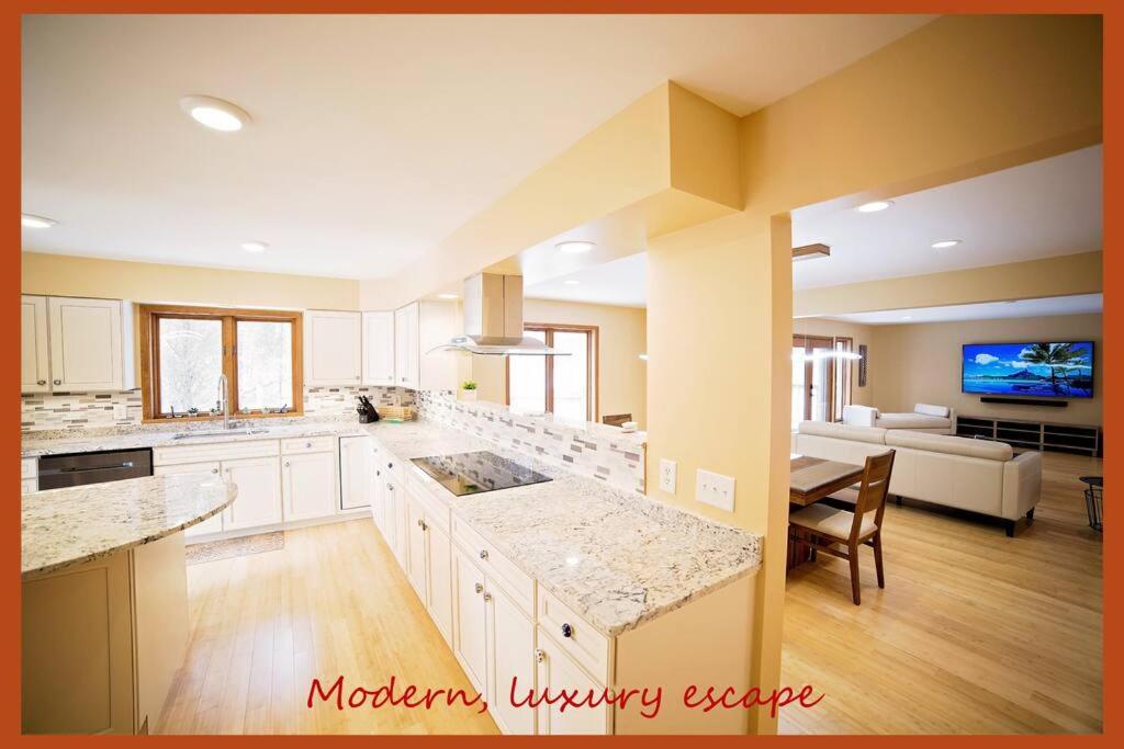 eine große Küche mit weißen Schränken und ein Wohnzimmer in der Unterkunft Luxurious Estate by Brown County 40 private acres in Columbus