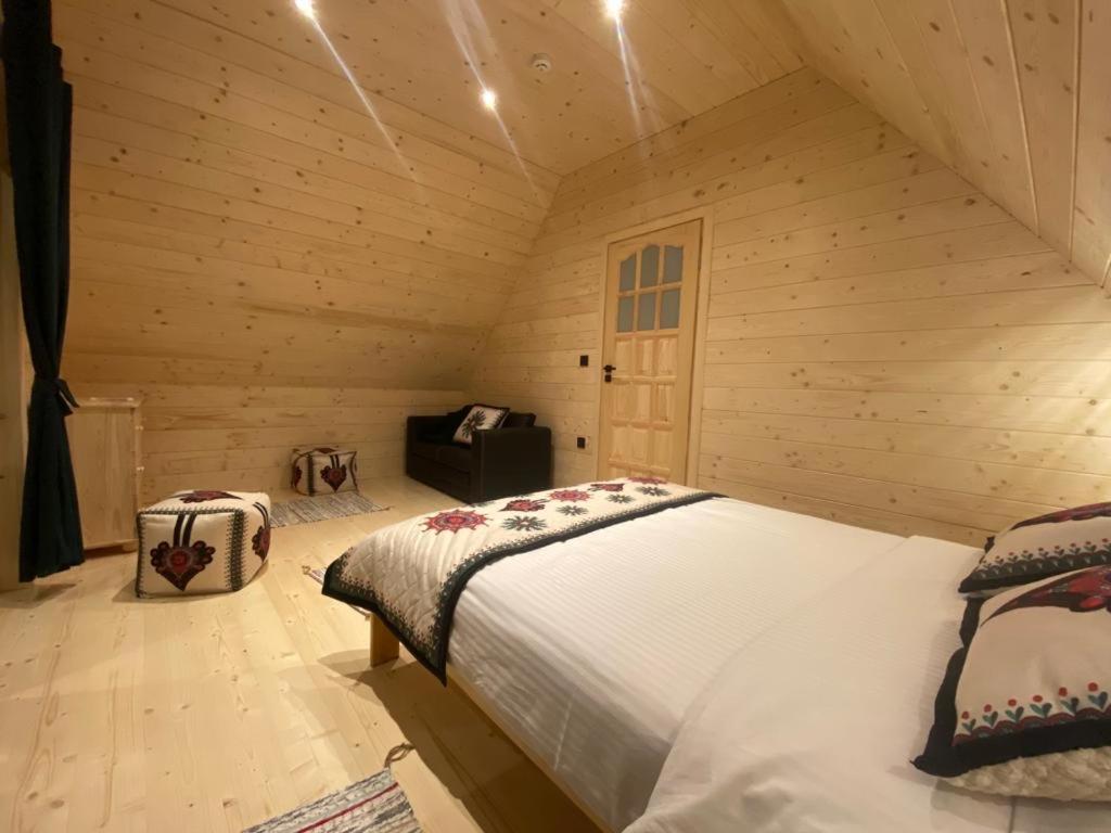 a bedroom with a bed in a wooden cabin at Góralskie Domki u Topora in Czarny Dunajec