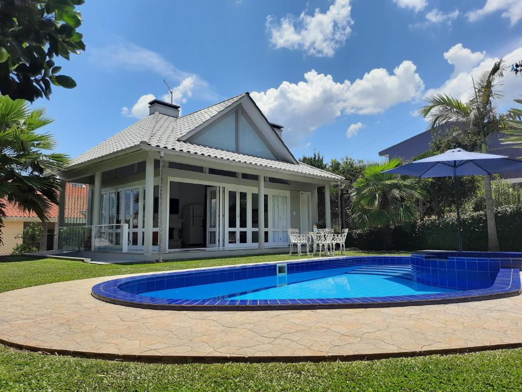 a house with a swimming pool in the yard at Casa da Piscina, Bento Gonçalves - Serra Gaúcha in Bento Gonçalves