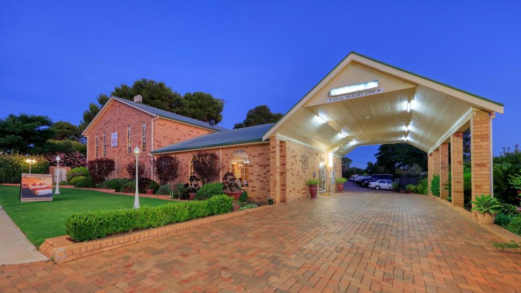 a brick building with a garage with a driveway at North Parkes Motel in Parkes