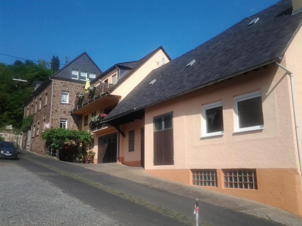 ein Gebäude mit schwarzem Dach auf einer Straße in der Unterkunft Weingut-Gästehaus Karl Otto Nalbach in Briedel