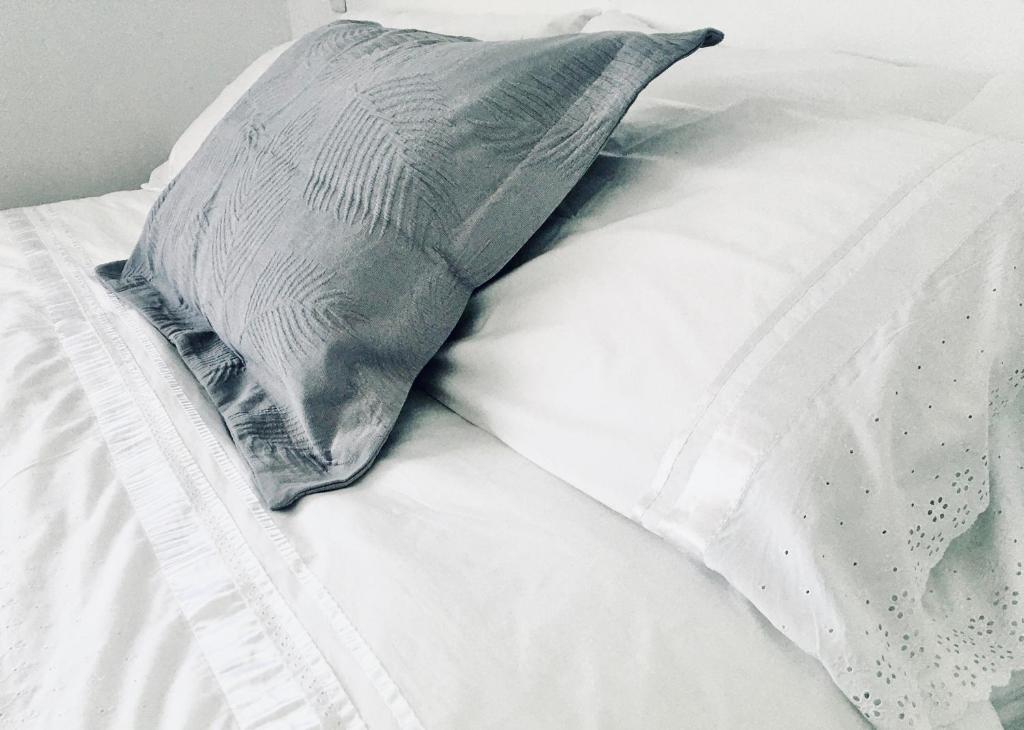 almohada sobre una cama blanca en Novaqua Bed & Breakfast en Olmué