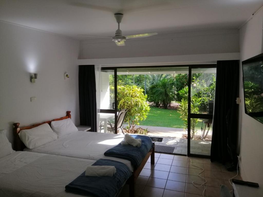 Un dormitorio con una cama y una puerta corrediza de vidrio. en Magnetic Island Resort, Sleeps 3, Free WIFI, en Nelly Bay