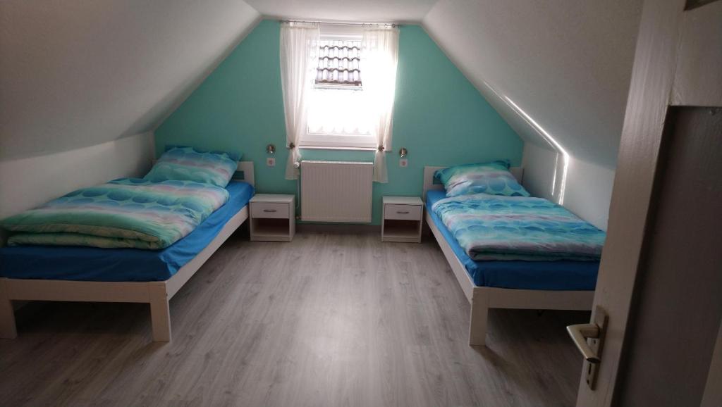 Pokój na poddaszu z 2 łóżkami i oknem w obiekcie Ferienhaus Scheerer w mieście Vöhl