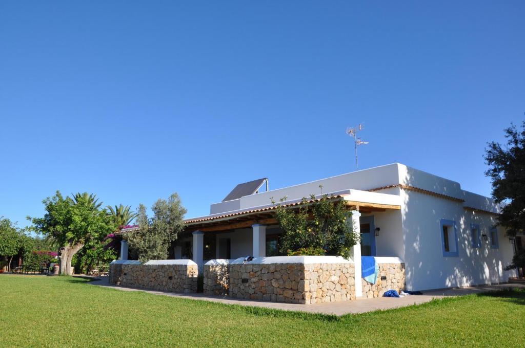 a house with a stone wall in a yard at Sa Vinya d'en Palerm in Sant Miquel de Balansat