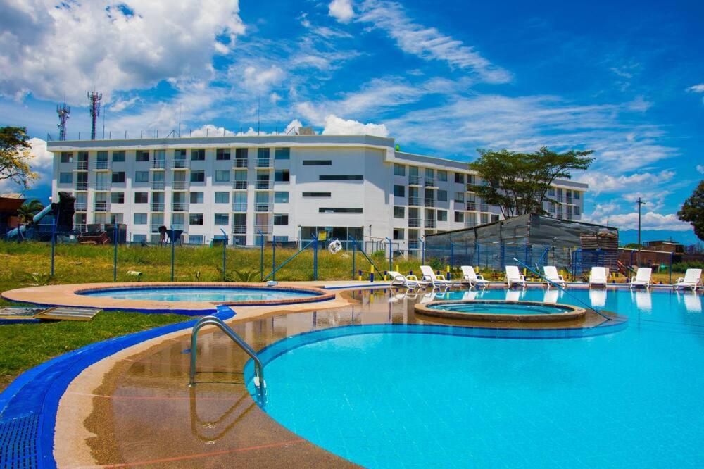een hotel met drie zwembaden en stoelen voor een gebouw bij BRISAS DEL QUINDIo 2 apto 203 A in Montenegro