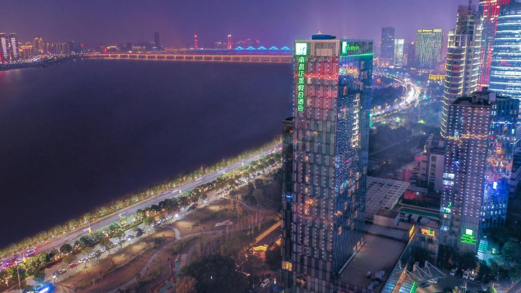 a city skyline at night with a tall building at Holiday Inn Nanchang Riverside by IHG in Nanchang