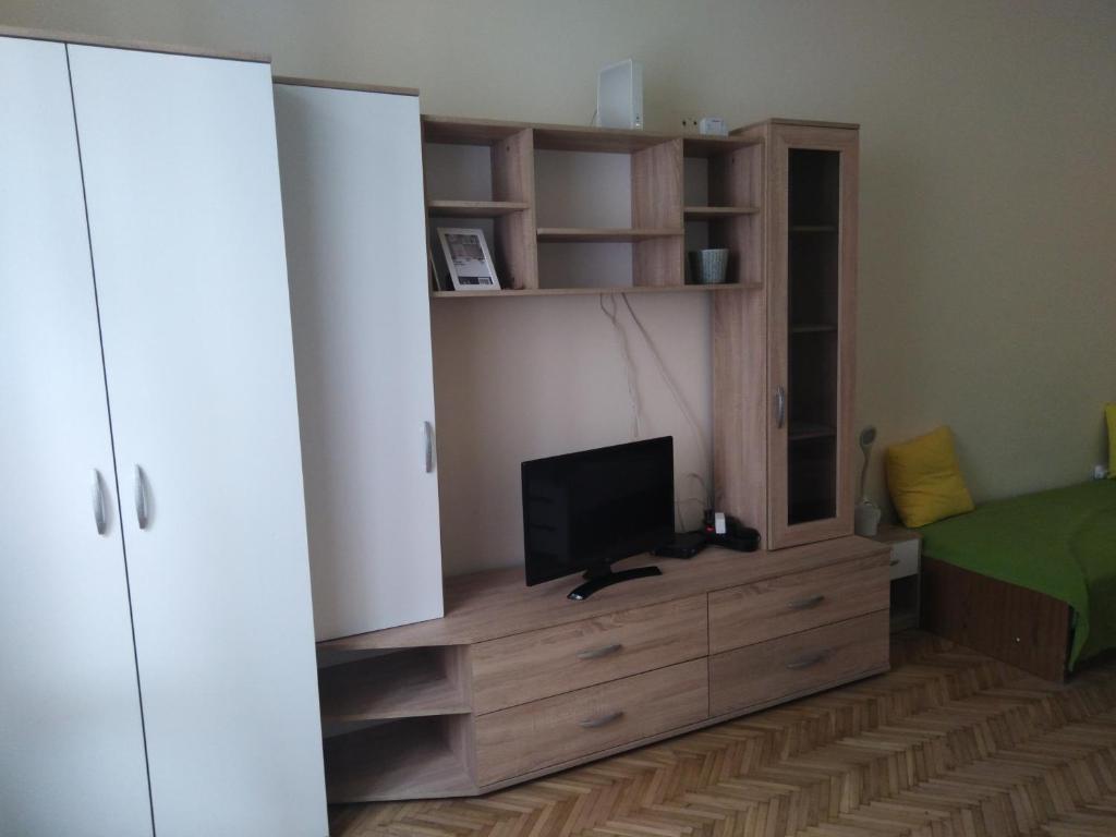 1 dormitorio con TV en un tocador de madera con cama en Adrienn apartment en Budapest