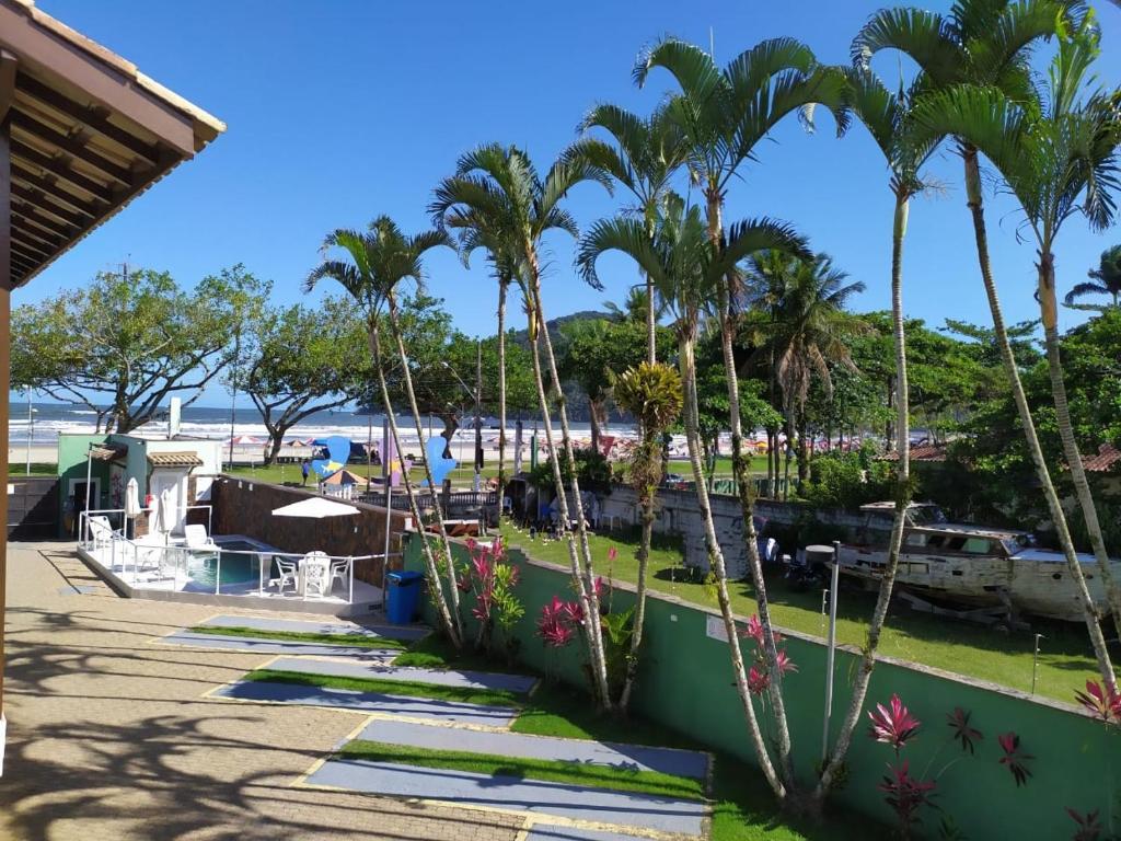 uma vista para a praia a partir de um resort com palmeiras em Morada Felice em Bertioga