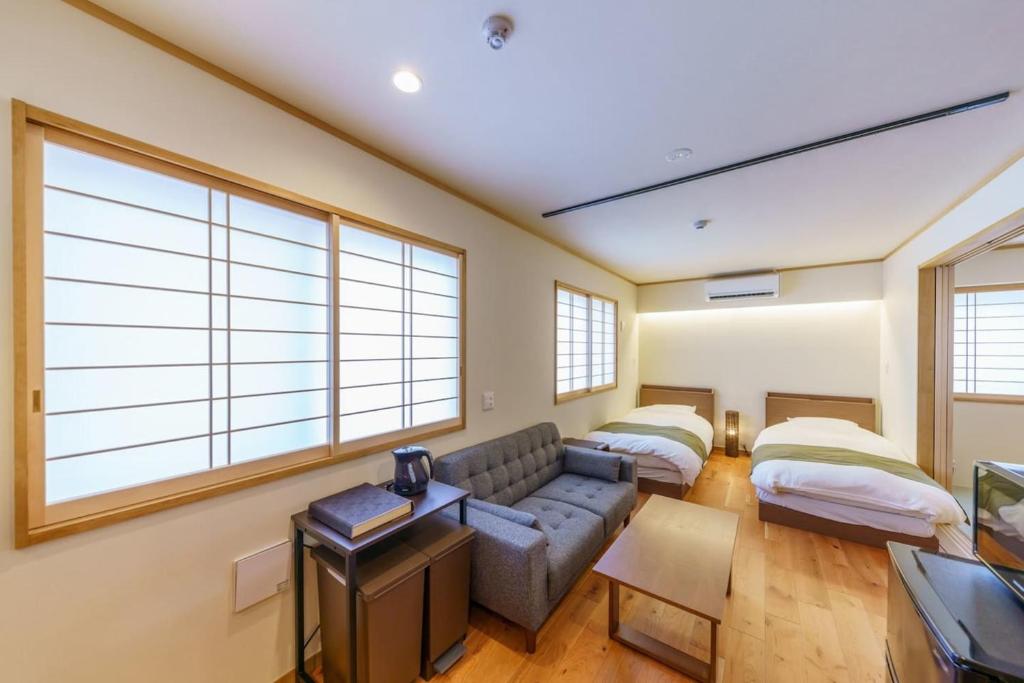 a living room with a couch and two beds at YADOYA 梟 in Tokyo