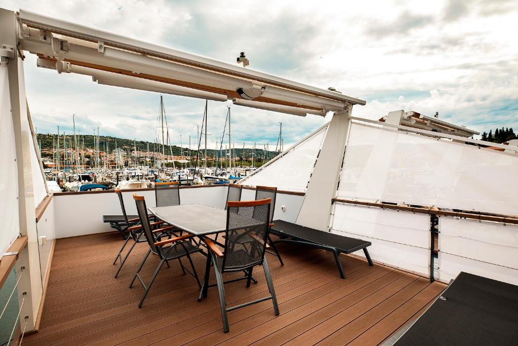 - Balcón con mesa y sillas en un barco en Categorical Floating House en Portorož