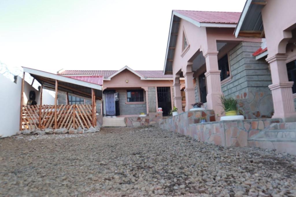 a house with a gravel driveway in front of it at Lux Suites Mara Holiday Homes in Narok