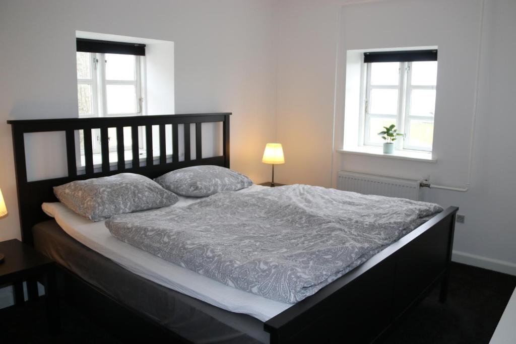 a bed in a bedroom with two pillows on it at Søndervang, ferielejlighed in Svinninge