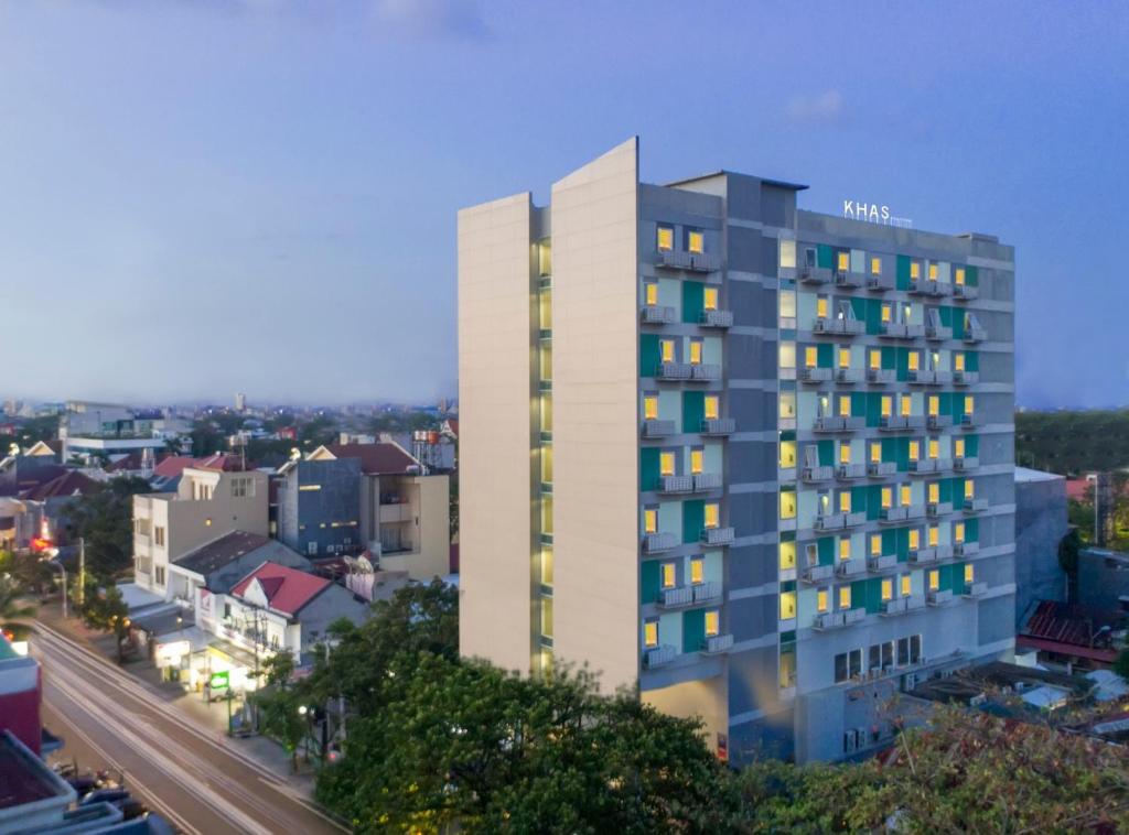 un grand bâtiment avec de nombreuses fenêtres dans une ville dans l'établissement KHAS Makassar Hotel, à Makassar