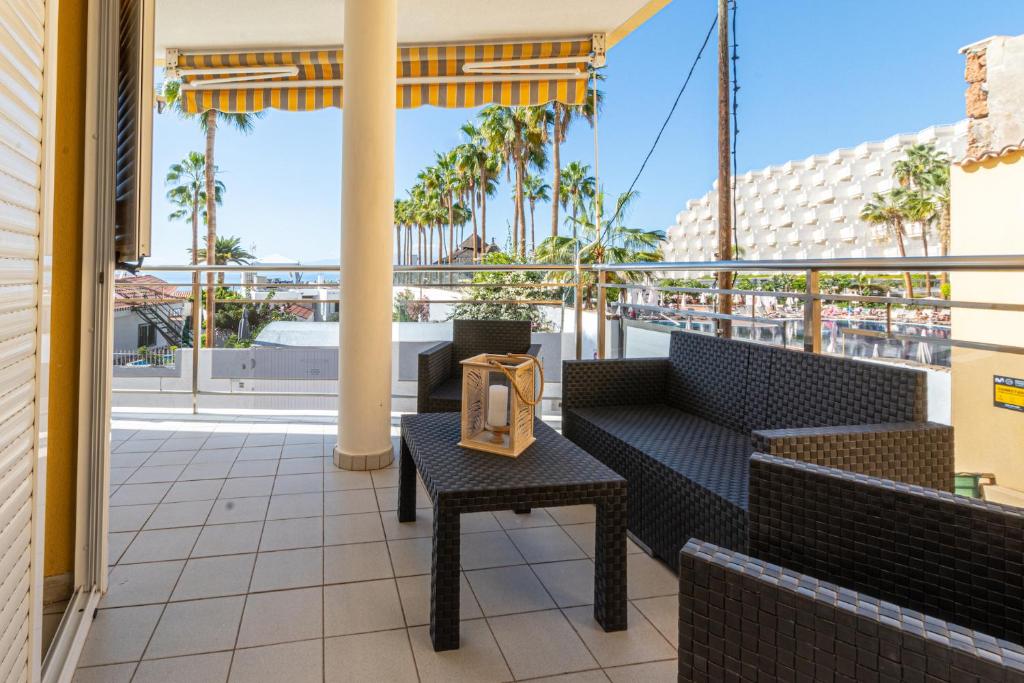 d'un balcon avec des chaises et une table avec un réveil. dans l'établissement La Perla Apartment in Playa de Arena by Dream Homes Tenerife, à Puerto de Santiago
